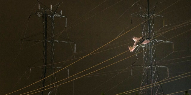 A small plane rests on live power lines after crashing, Sunday, Nov. 27, 2022, in Montgomery Village, a northern suburb of Gaithersburg, Md. 