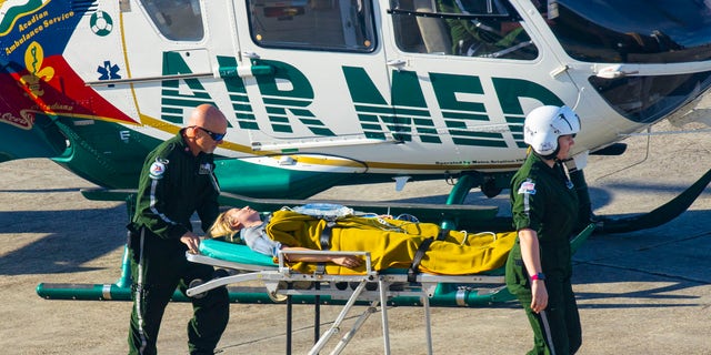 Emma Stone's character in "And" appears severely injured as she is transported to a helicopter to be airlifted.