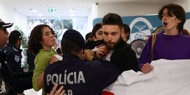 Police officers clash with climate change protesters.