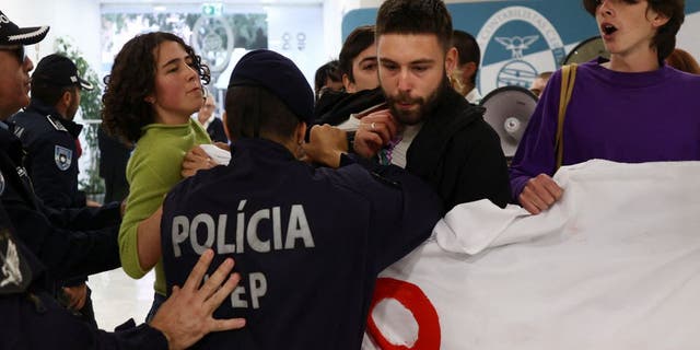 Police officers clash with climate change protesters.