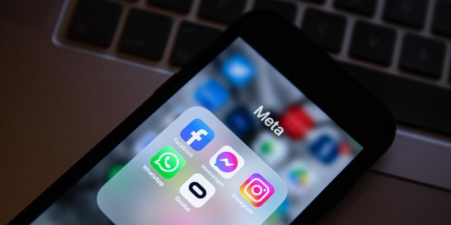 In this photo illustration, the app icons of Facebook, Messenger, Instagram, WhatsApp, and Oculus VR are displayed on a smartphone screen with a Meta logo in the background. 