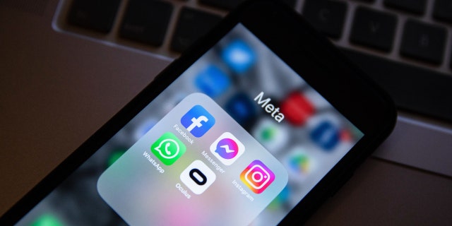 In this photo illustration, the app icons of Facebook, Messenger, Instagram, WhatsApp, and Oculus VR are displayed on a smartphone screen with a Meta logo in the background.