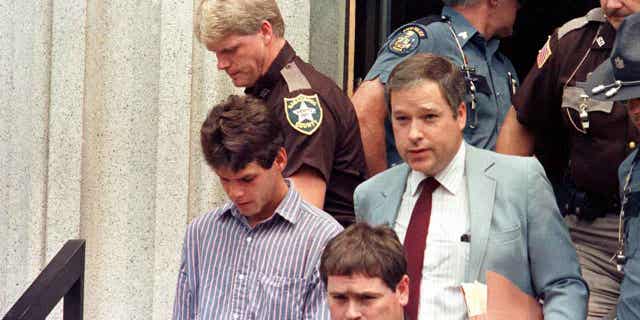Dennis Dechaine, left, is led out of the Sagadahoc County courthouse, in West Bath, Maine, in August 1988. Dechaine, who was convicted of killing 12-year-old Sarah Cherry, will seek a new trial based on new DNA test results.