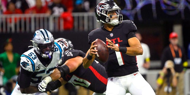 Falcons quarterback Marcus Mariota throws as Carolina Panthers defensive end Brian Burns defends, Sunday, Oct. 30, 2022, in Atlanta.