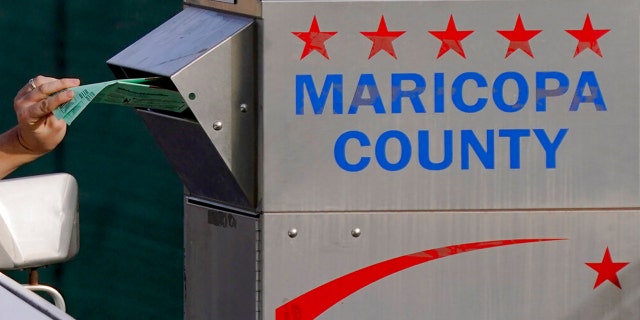 FILE: A voter casts their ballot at a secure ballot drop box at the Maricopa County Tabulation and Election Center in Phoenix, Nov. 1, 2022.