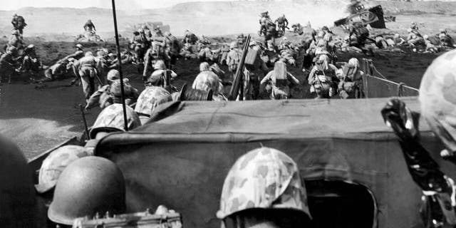 Fourth Division Marines charging from their landing craft onto the beach in the battle at Iwo Jima, Japan. Jack Chevigny, the star of Notre Dame's legendary