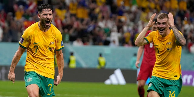 Australia's Mathew Leckie, left, celebrates with teammate Riley McGree after scoring his team's first goal during the World Cup Group D soccer match between Australia and Denmark, at the Al Janoub Stadium in Al Wakrah, Qatar, on Wednesday, November 30, 2022. 