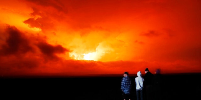 People watch Mauna Loa eruption, Monday, Nov. 28, 2022, near Hilo, Hawaii. 