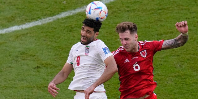 Iran's Mehdi Taremi, left, duels for the ball with Wales' Joe Rodon during the World Cup Group B match at Ahmad bin Ali Stadium in Al Rayyan, Qatar, Nov. 25, 2022.