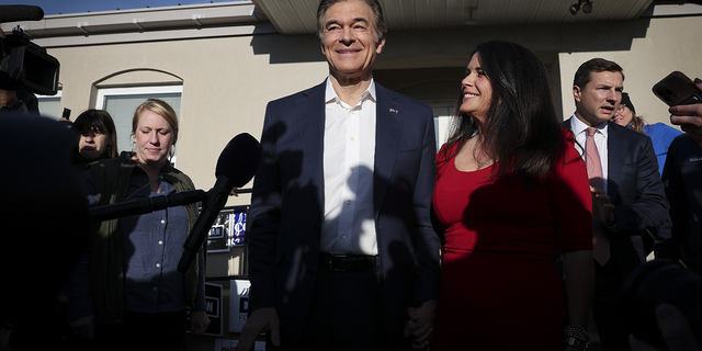 Republican U.S. Senate candidate Dr. Mehmet Oz answers brief questions with his wife Lisa Oz after casting his ballot at the Bryn Athyn Borough Hall on Nov. 8 in Huntingdon Valley, Pennsylvania.