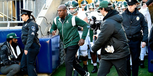 Michigan State head coach Mel Tucker leads the team out the tunnel onto the field with two police escorts during the Michigan State Spartans versus Penn State Nittany Lions game on November 26, 2022 at Beaver Stadium in University Park, PA.