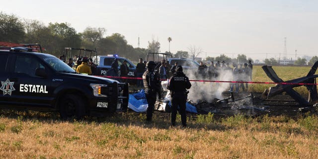 Firefighters and members of security forces check covered bodies where the head of security of the central Mexican state of Aguascalientes has died in a helicopter crash, in Aguascalientes, Mexico, on Nov. 17, 2022.