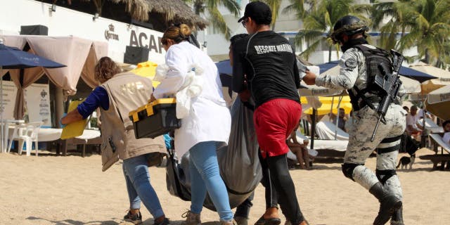 Forensic technicians and security forces move one of three bodies that washed ashore at Icacos Beach in Acapulco, Mexico, Nov. 12, 2022.