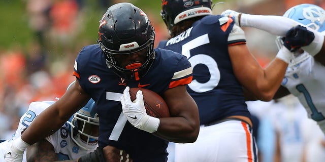 Virginia Cavaliers running back Mike Hollins (7) rushes up field while attempting to elude North Carolina Tar Heels linebacker Power Echols (23) during a college football game between the North Carolina Tar Heels and the Virginia Cavaliers on November 05, 2022, at Scott Stadium in Charlottesville, VA.