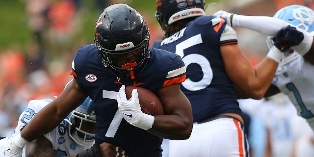 Virginia Cavaliers running back Mike Hollins (7) rushes up field while attempting to elude North Carolina Tar Heels linebacker Power Echols (23) during a college football game between the North Carolina Tar Heels and the Virginia Cavaliers on November 05, 2022, at Scott Stadium in Charlottesville, VA.