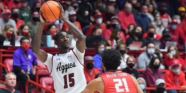 Mike Peake #15 de los New Mexico State Aggies busca pasar contra Jay Allen-Tovar #21 de los New Mexico Lobos durante su juego en The Pit el 6 de diciembre de 2021 en Albuquerque, Nuevo México.  