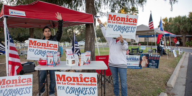 Jordan De La Garza, left, and Nidia Garza, right, campaign for Republican Congressional candidate Monica De La Cruz-Hernandez on the last day of early voting at the Lark Community Center McAllen, Texas on October 30, 2020. 