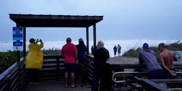 People brave rain and strong winds to visit Jensen Beach rk as conditions deteriorate with the approach of Hurricane Nicole, Wednesday, Nov.  9, 2022, in Jensen Beach, Fla. 