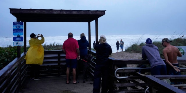 People brave rain and strong winds to visit Jensen Beach Park as conditions deteriorate with the approach of Hurricane Nicole, Wednesday, Nov. 9, 2022, in Jensen Beach, Fla.