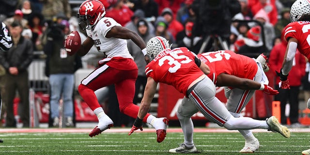 Dexter Williams II (5) of the Indiana Hoosiers tries to get past Tommy Eichenberg (35) and Michael Hall Jr. (51) of the Ohio State Buckeyes during the second quarter of a game at Ohio Stadium on November 12, 2022 in Columbus , USA.  Ohio.