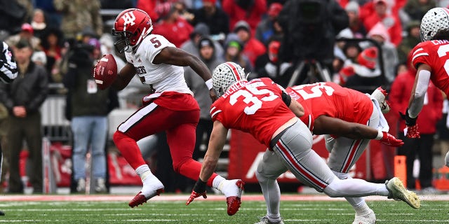 Dexter Williams II (5) of the Indiana Hoosiers attempts to outrun Tommy Eichenberg (35) and Michael Hall Jr. (51) of the Ohio State Buckeyes during the second quarter of a game at Ohio Stadium Nov. 12, 2022, in Columbus, Ohio.