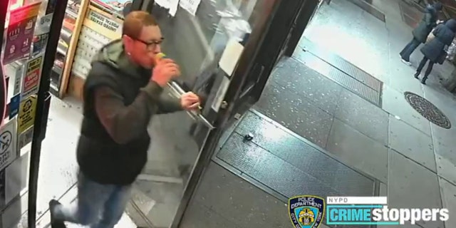 The suspect walks out with a drink from the store