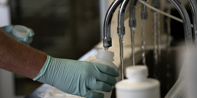 A geologist collects samples of treated Lake Michigan water in a laboratory in Wilmette, Illinois, on July 3, 2021.