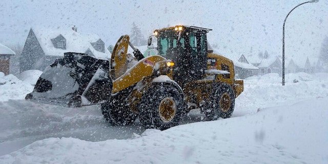 A front end loader moves snow from a residential street, Friday, Nov. 18, 2022, in Buffalo, N.Y. A dangerous lake-effect snowstorm paralyzed parts of western and northern New York, with nearly 2 feet of snow already on the ground in some places and possibly much more on the way. 