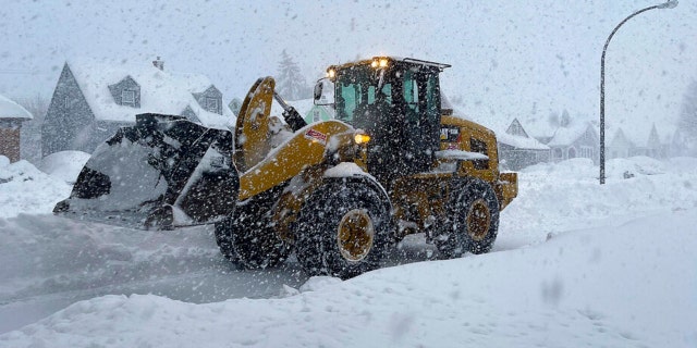 A front end loader moves snow from a residential street, Friday, Nov. 18, 2022, in Buffalo, N.Y. A dangerous lake-effect snowstorm paralyzed parts of western and northern New York, with nearly 2 feet of snow already on the ground in some places and possibly much more on the way.
