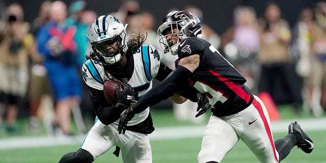 Carolina Panthers cornerback Donte Jackson, left, intercepts a pass intended for Atlanta Falcons wide receiver Damiere Byrd, right, during the first half of a game Oct. 30, 2022, in Atlanta.