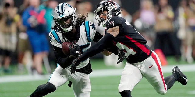 Carolina Panthers cornerback Donte Jackson, left, intercepts a pass intended for Atlanta Falcons wide receiver Damiere Byrd, right, during the first half of a game Oct. 30, 2022, in Atlanta.