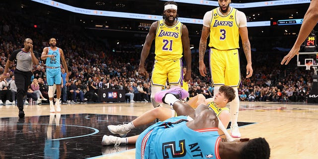 El No. 21 de Los Angeles Lakers, Patrick Beverley, reacciona después de empujar al suelo al No. 22 Deandre Ayton de los Phoenix Suns junto al No. 3 Anthony Davis y el No. 15 Austin Reaves durante la segunda mitad del partido de la NBA en el Footprint Center en noviembre. 22 de febrero de 2022 en Fénix.