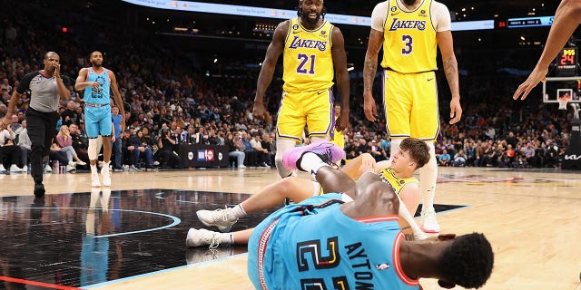 El No. 21 de Los Angeles Lakers, Patrick Beverley, reacciona después de empujar al suelo al No. 22 Deandre Ayton de los Phoenix Suns junto al No. 3 Anthony Davis y el No. 15 Austin Reaves durante la segunda mitad del partido de la NBA en el Footprint Center en noviembre. 22 de febrero de 2022 en Fénix.