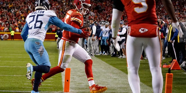 Kansas City Chiefs quarterback Patrick Mahomes (15) scores a 2-point conversion past Tennessee Titans cornerback Kristian Fulton (26) as Chiefs' wide receiver JuJu Smith-Schuster (9) watches during the second half of an NFL football game Sunday, Nov. 6, 2022, in Kansas City, Mo.