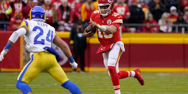Kansas City Chiefs quarterback Patrick Mahomes (15) climbs up the field in front of Los Angeles Rams safety Taylor Rapp (24) during the first half of an NFL football game Sunday, November 27, 2022, in Kansas City, Missouri.