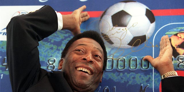 Soccer great Pele gestures to throw a cardboard soccer ball at a promotional news conference for Hong Kong Bank's new World Cup Visa card, February 24 in Hong Kong.  Brazil is likely to bid to host the 2006 World Cup, against countries including Germany, England and South Africa, according to the Brazilian sports legend, who is in Hong Kong on business and to attend a coaching school.