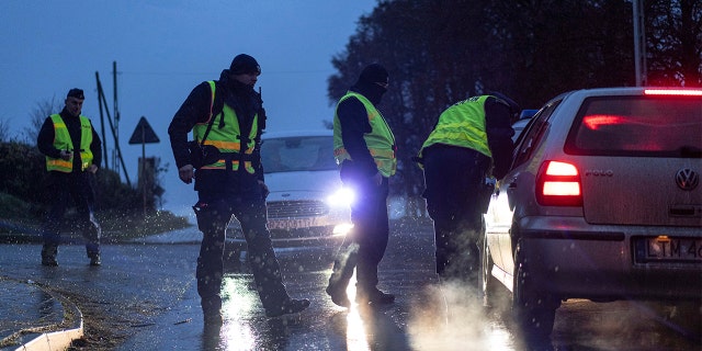 Police officers check documents at a checkpoint near the scene of the explosion in Przewodow, Poland, Wednesday, Nov. 16, 2022.
