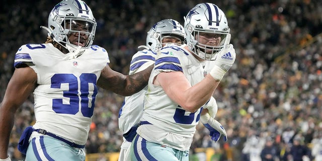 Dallas Cowboys' Qadree Ollison, #30, Luke Gifford, #57, and C.J. Goodwin, rear, celebrate after making a stop on a Green Bay Packers punt return during the second half of an NFL football game Sunday, Nov. 13, 2022, in Green Bay, Wisconsin.