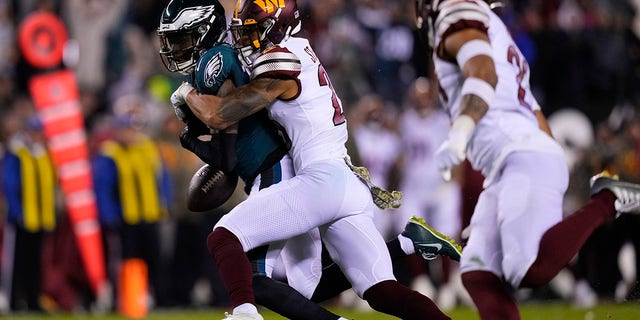 Philadelphia Eagles wide receiver Quez Watkins (16) fumbles the ball against Washington Commanders cornerback Benjamin St-Juste (25) during the second half of an NFL football game, Monday, Nov. 14, 2022, in Philadelphia. 