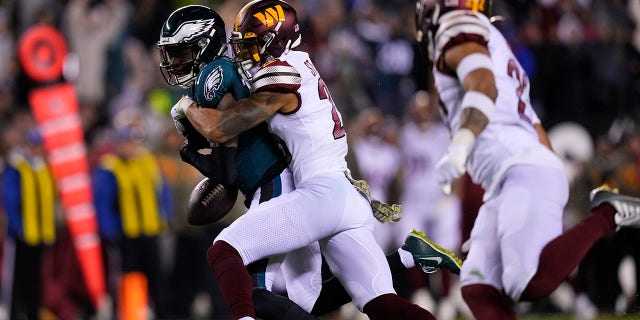 Philadelphia Eagles wide receiver Quez Watkins (16) fumbles the ball against Washington Commanders cornerback Benjamin St-Juste (25) during the second half of an NFL football game, Monday, Nov. 14, 2022, in Philadelphia.