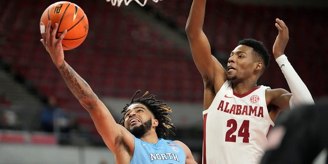 North Carolina guard RJ Davis goes to the basket as Alabama forward Brandon Miller defends at the Phil Knight Invitational on November 27, 2022 in Portland, Oregon.