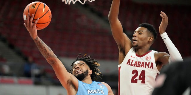 El guardia de Carolina del Norte, RJ Davis, va a la canasta mientras el alero de Alabama, Brandon Miller, defiende en el Phil Knight Invitational el 27 de noviembre de 2022 en Portland, Oregón.