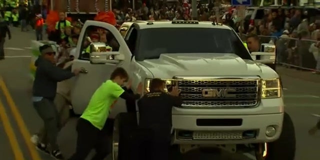 People stop a truck during the Raleigh, North Carolina, Christmas parade on Saturday.  A girl was injured in an accident.
