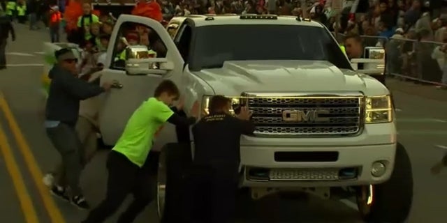 People stop a truck during the Raleigh, North Carolina Christmas parade Saturday. A girl was injured in an accident.