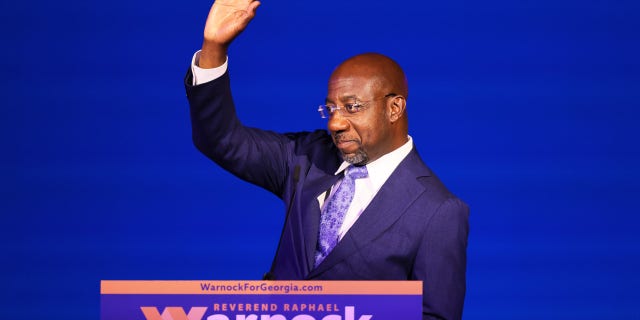 Sen.  Raphael Warnock waves after giving a speech at his election night party on Nov. 8, 2022, in Atlanta. 