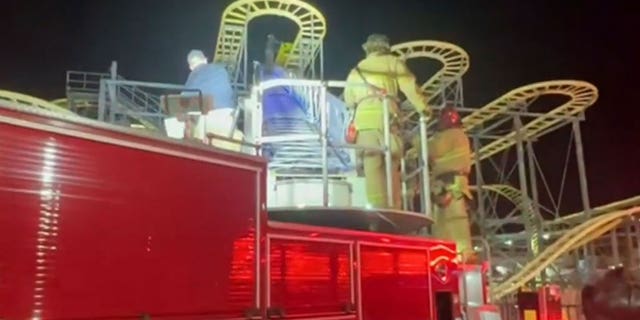 Firefighters make their way up the aerial ladder to rescue the trapped teenagers in North Highlands, California.