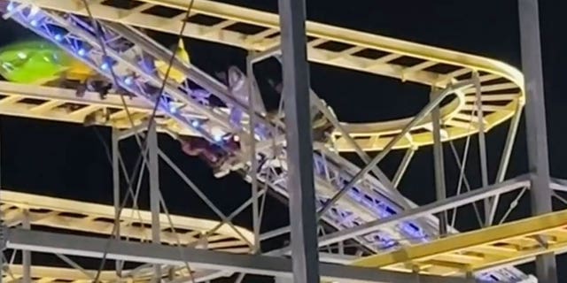 Firefighters and one of the formerly trapped teens walk down the aerial ladder after the teenager was stuck 65 feet in the air on a roller coaster in North Highlands, California.