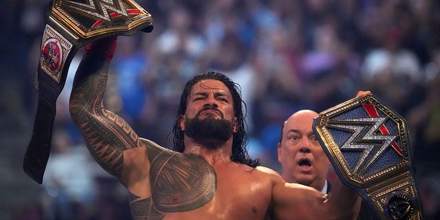 Roman Reigns celebrates after unifying the WWE Championship and the Universal Championship during WrestleMania, April 3, 2022, in Arlington Texas.