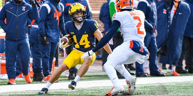 Roman Wilson (14) of the Michigan Wolverines rushes against Matthew Bailey (2) of the Illinois Fighting Illini during the first half at Michigan Stadium Nov. 19, 2022, in Ann Arbor, Mich.