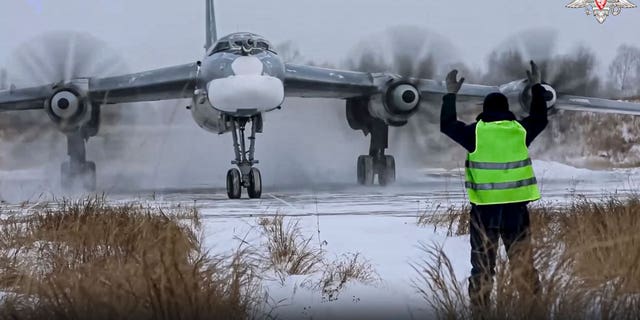 In this handout photo taken from video released by the Russian Defense Ministry Press Service on Nov. 30, 2022, a view of a Tu-95 strategic bomber of the Russian air force taxiing before takeoff for a joint air patrol with Chinese bombers at an airbase in an unspecified location in Russia.